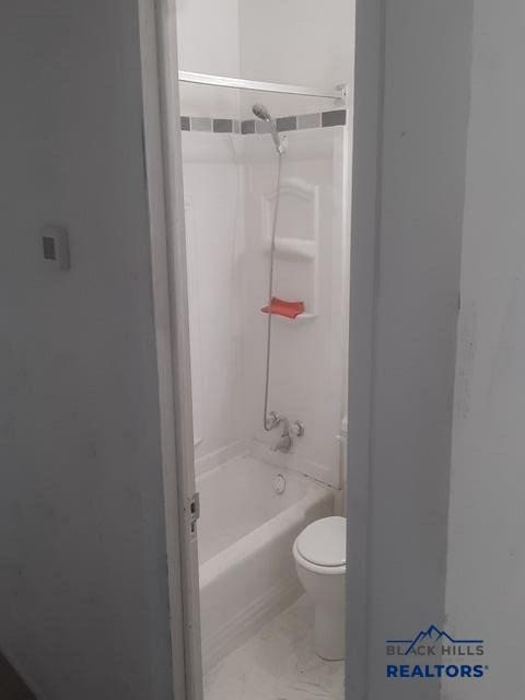 bathroom featuring shower / bathtub combination and toilet