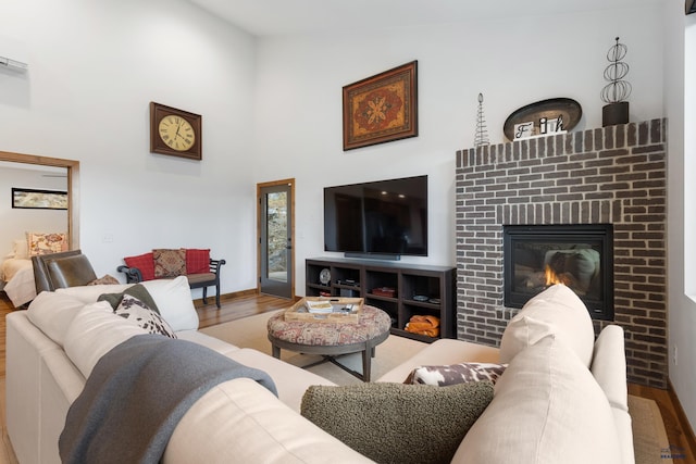 23974 Thompson Dr, Hill City, SD 57745 - living area featuring wood finished floors, high vaulted ceiling, and a brick fireplace