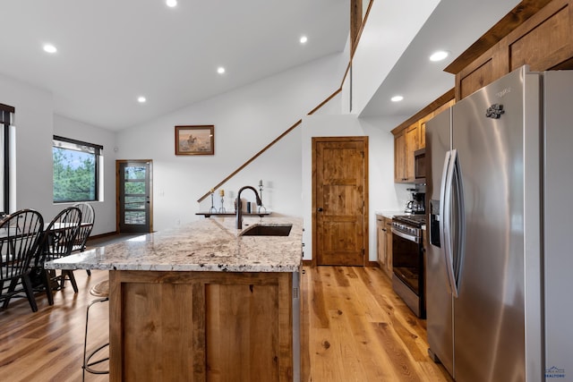 23974 Thompson Dr, Hill City, SD 57745 - kitchen with appliances with stainless steel finishes, an island with sink, light wood-type flooring, lofted ceiling, and recessed lighting
