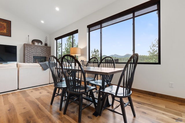 23974 Thompson Dr, Hill City, SD 57745 - dining space featuring a brick fireplace, light wood-style floors, recessed lighting, and vaulted ceiling