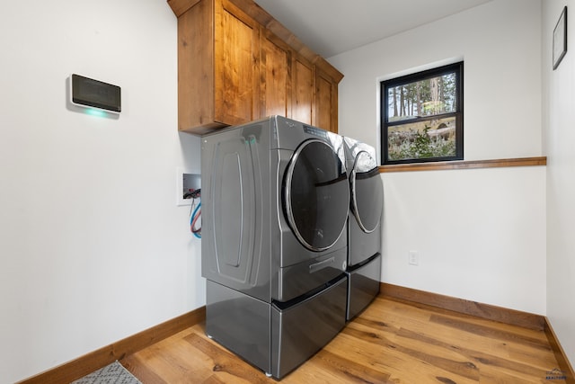 23974 Thompson Dr, Hill City, SD 57745 - laundry room featuring cabinet space, light wood-type flooring, and separate washer and dryer