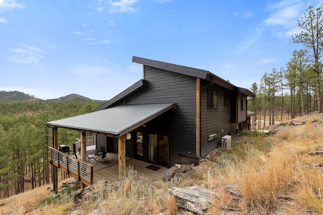 23974 Thompson Dr, Hill City, SD 57745 - view of property exterior featuring a deck with mountain view and a view of trees