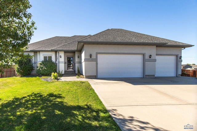 prairie-style home with a front yard and a garage