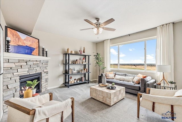 carpeted living room with a fireplace and ceiling fan