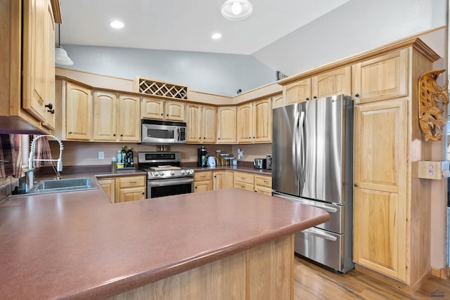 kitchen with light hardwood / wood-style floors, sink, lofted ceiling, kitchen peninsula, and appliances with stainless steel finishes