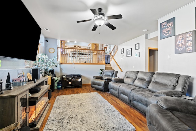 living room featuring ceiling fan and hardwood / wood-style floors