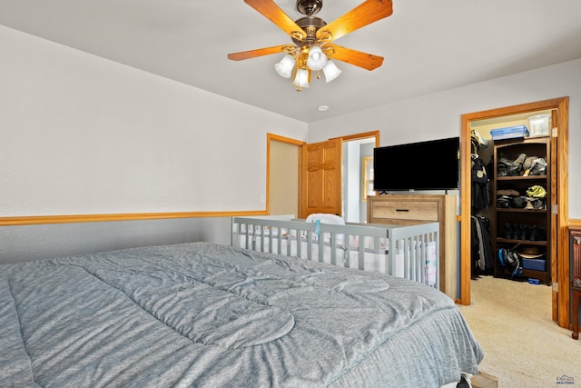 carpeted bedroom with a spacious closet, a closet, and ceiling fan