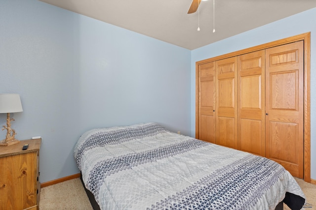 carpeted bedroom with ceiling fan and a closet