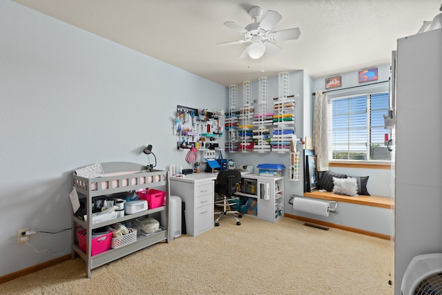 carpeted home office featuring ceiling fan