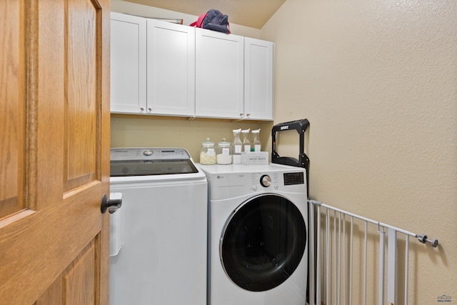 laundry area with washer and clothes dryer and cabinets