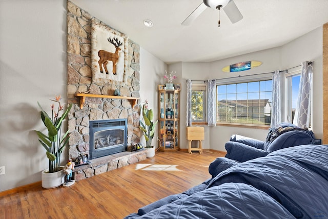 living room featuring ceiling fan, a fireplace, plenty of natural light, and hardwood / wood-style floors