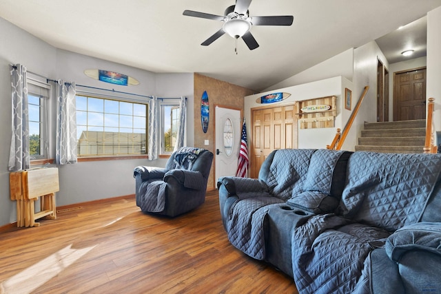 living room featuring wood-type flooring, lofted ceiling, and ceiling fan