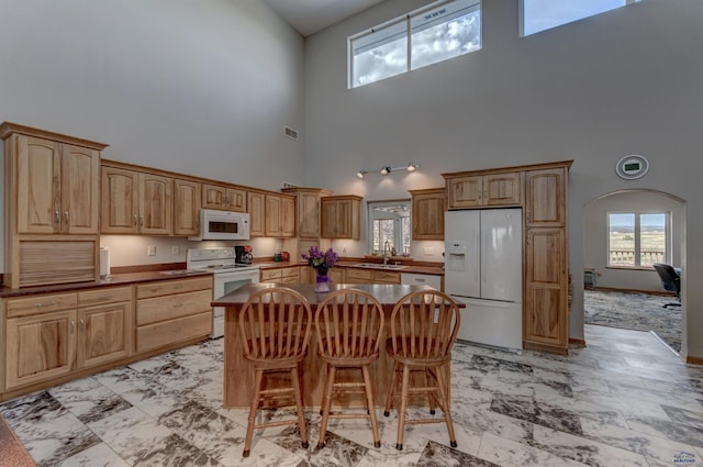 11845 N Haines Ave, Rapid City, SD 57701 - kitchen featuring white appliances, visible vents, a center island, a sink, and dark countertops