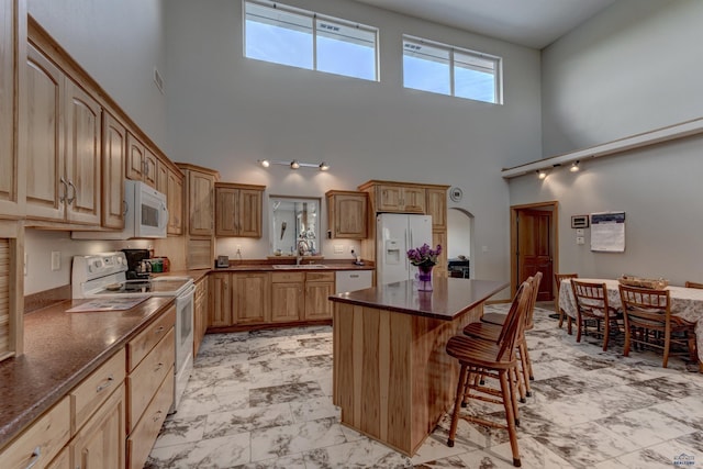 11845 N Haines Ave, Rapid City, SD 57701 - kitchen with visible vents, a center island, a sink, a breakfast bar, and white appliances