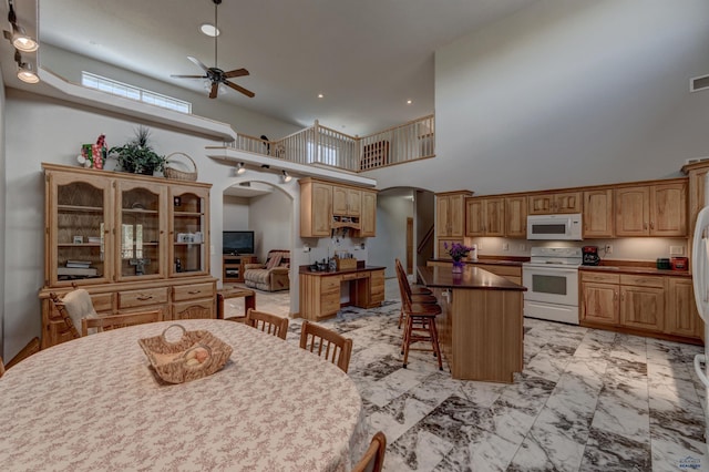 11845 N Haines Ave, Rapid City, SD 57701 - dining space with a towering ceiling, visible vents, ceiling fan, arched walkways, and marble finish floor
