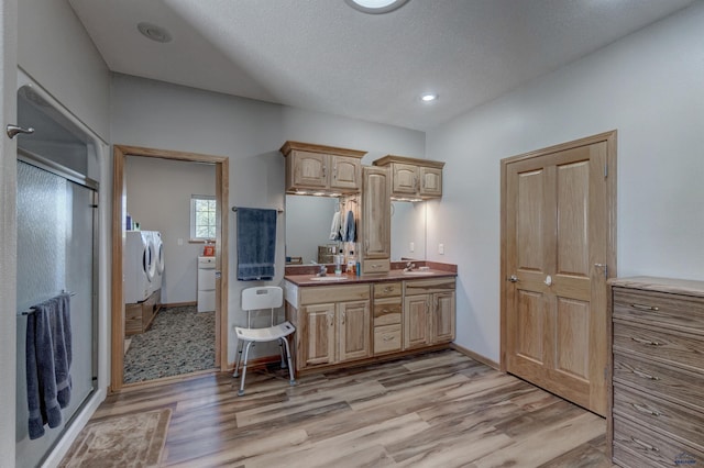 11845 N Haines Ave, Rapid City, SD 57701 - kitchen with a sink, washing machine and dryer, light wood-style floors, and light brown cabinets