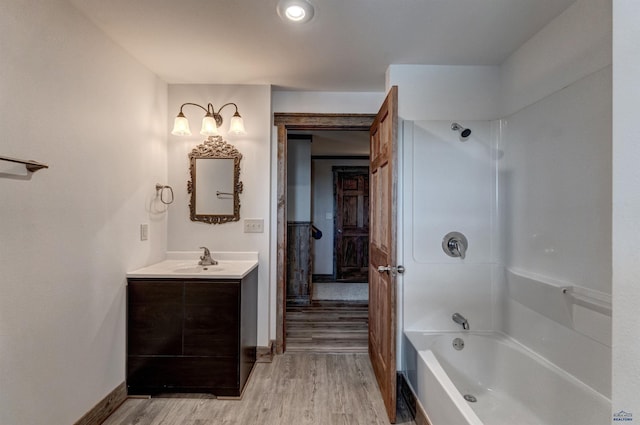 11845 N Haines Ave, Rapid City, SD 57701 - full bathroom featuring vanity, baseboards, tub / shower combination, and wood finished floors