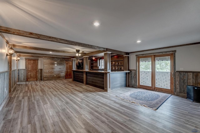 11845 N Haines Ave, Rapid City, SD 57701 - unfurnished living room featuring light wood finished floors, beamed ceiling, a wainscoted wall, and ceiling fan