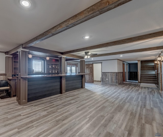 11845 N Haines Ave, Rapid City, SD 57701 - interior space featuring open floor plan, open shelves, a wainscoted wall, beam ceiling, and light wood finished floors