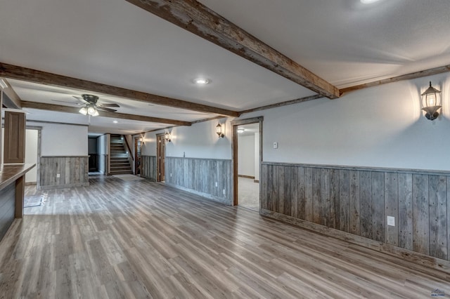 11845 N Haines Ave, Rapid City, SD 57701 - unfurnished living room with wood finished floors, beamed ceiling, stairs, and a wainscoted wall