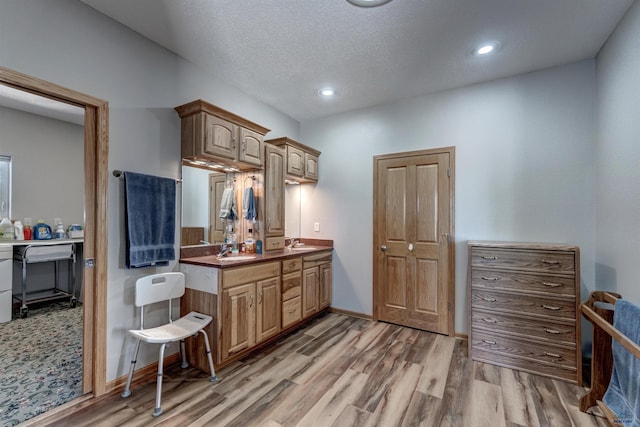 11845 N Haines Ave, Rapid City, SD 57701 - kitchen with baseboards, recessed lighting, light wood-style flooring, a textured ceiling, and a sink