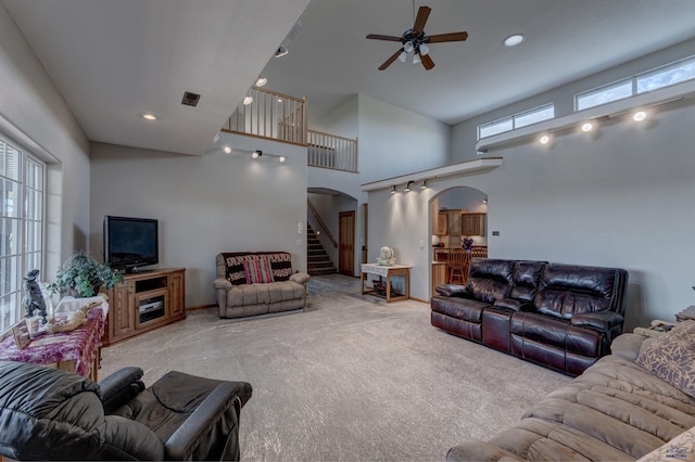 11845 N Haines Ave, Rapid City, SD 57701 - living room with arched walkways, a high ceiling, a ceiling fan, stairs, and carpet flooring