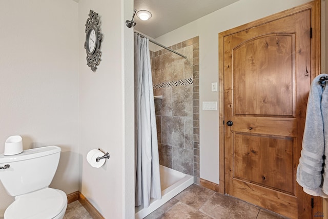 bathroom with tile patterned flooring, toilet, and curtained shower