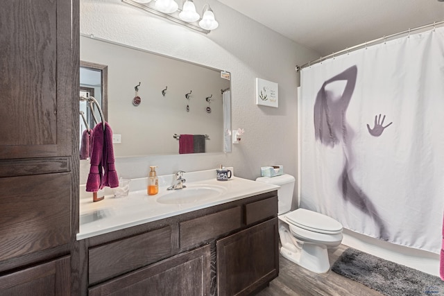 bathroom with a shower with shower curtain, hardwood / wood-style flooring, vanity, and toilet