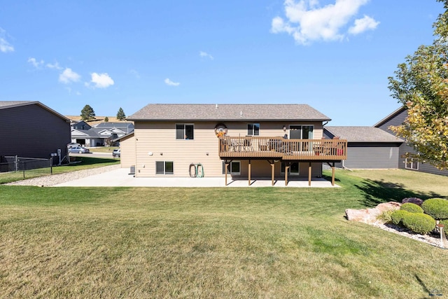 rear view of property featuring a lawn, a wooden deck, and a patio area