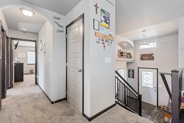 hall featuring a healthy amount of sunlight and light carpet