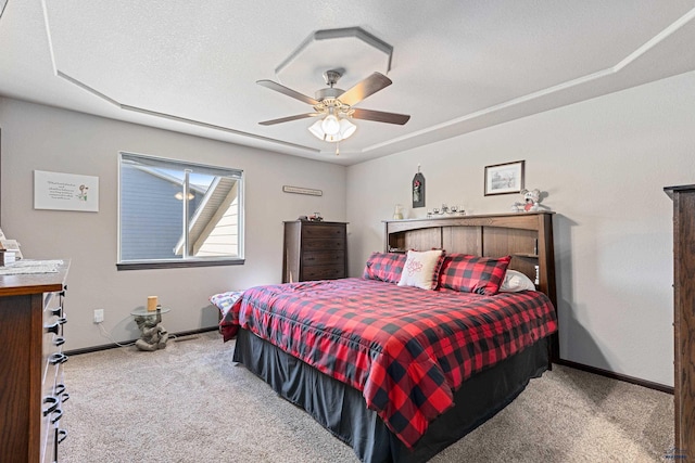 bedroom with ceiling fan, light colored carpet, and a textured ceiling