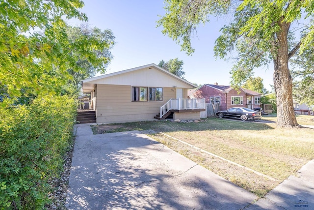 view of front of house featuring a front lawn and a deck