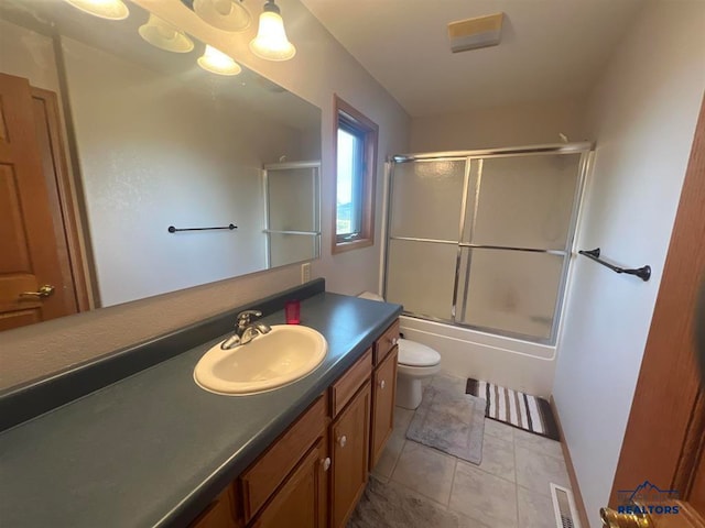 full bathroom featuring tile patterned flooring, vanity, toilet, and bath / shower combo with glass door