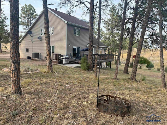 back of property featuring a deck and central AC