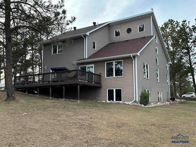 rear view of property with a wooden deck and a yard