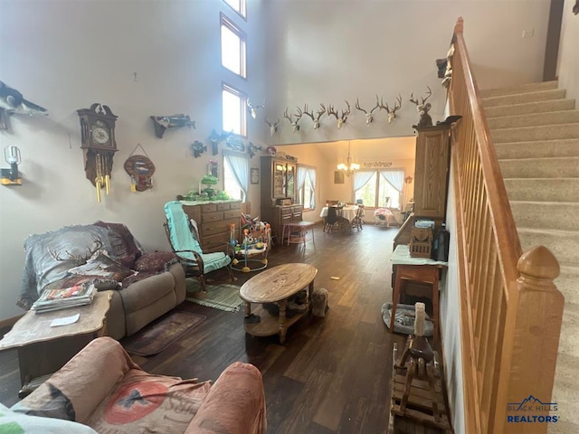 living room with a notable chandelier, a high ceiling, and dark hardwood / wood-style floors