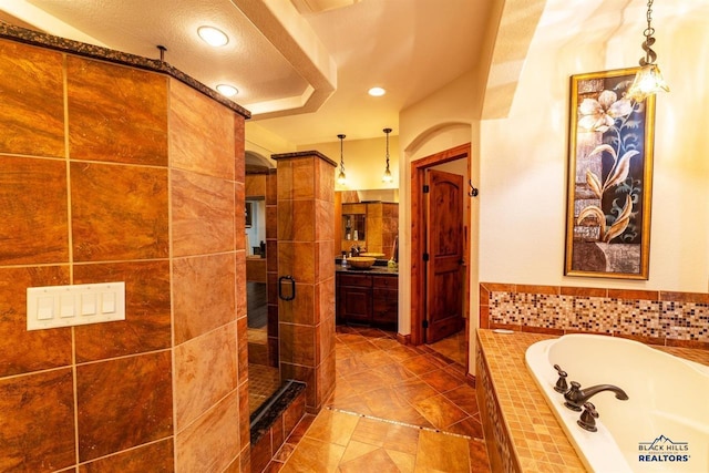 bathroom featuring a textured ceiling, tile patterned flooring, vanity, and shower with separate bathtub