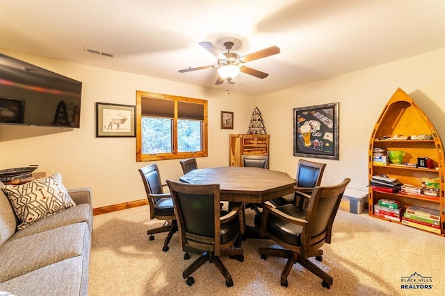 carpeted dining area with ceiling fan