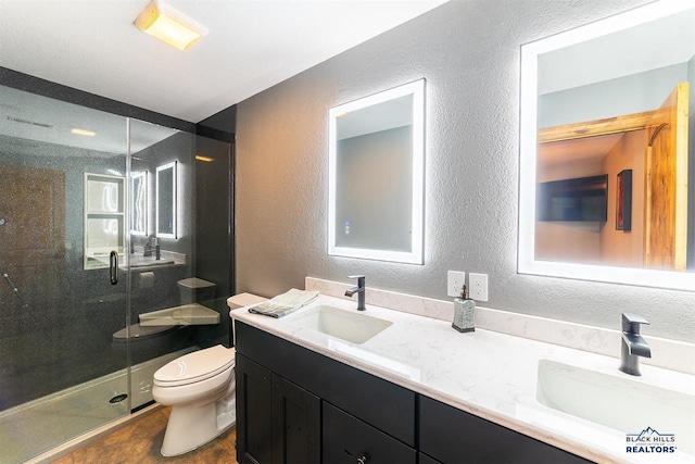 bathroom featuring vanity, a shower with door, toilet, and a wealth of natural light