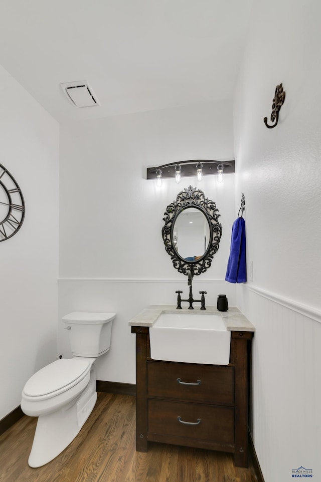 bathroom featuring wood-type flooring, vanity, and toilet