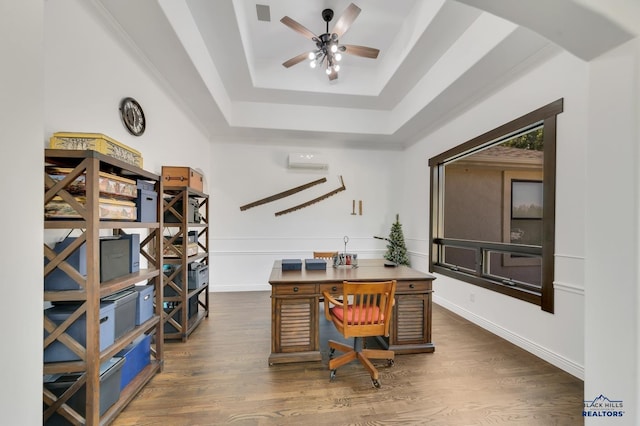 office space with dark wood-type flooring, a wall mounted AC, a tray ceiling, and ceiling fan