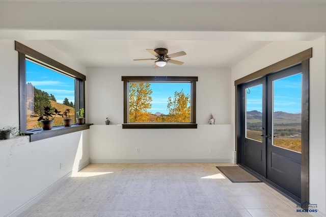 interior space featuring ceiling fan, a mountain view, and plenty of natural light