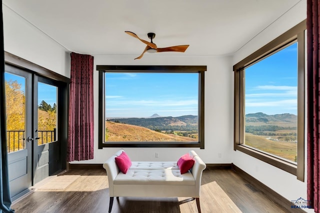 sunroom / solarium featuring ceiling fan, a mountain view, french doors, and a wealth of natural light