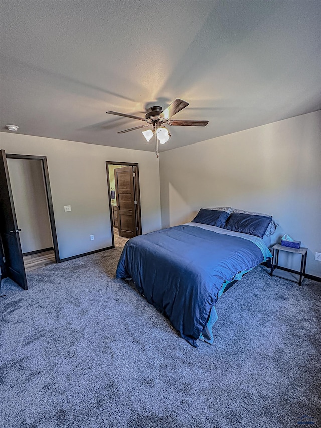 carpeted bedroom featuring ceiling fan and a textured ceiling