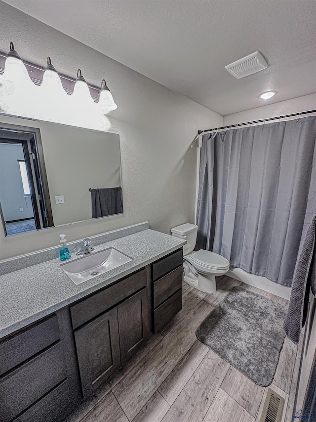 bathroom with vanity, hardwood / wood-style flooring, and toilet