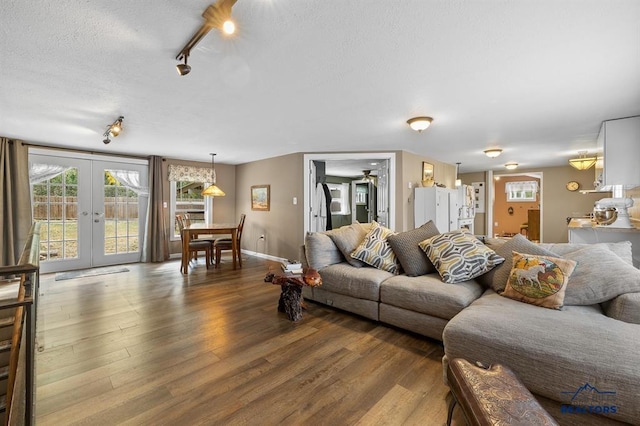 living room with french doors, ceiling fan, wood-type flooring, and a textured ceiling