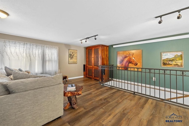 living room with dark hardwood / wood-style floors and track lighting