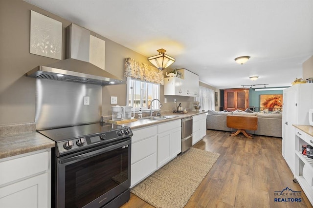 kitchen featuring black / electric stove, wall chimney exhaust hood, white cabinetry, and wood-type flooring