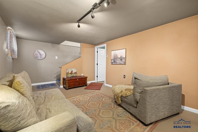 living room with track lighting, baseboards, and stairs