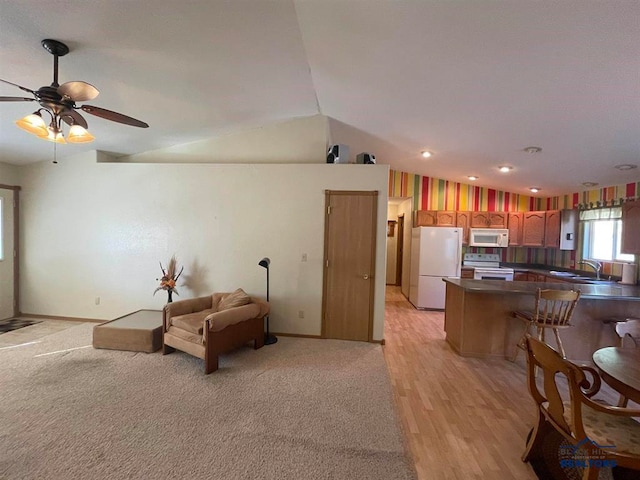 kitchen featuring white appliances, lofted ceiling, sink, kitchen peninsula, and ceiling fan